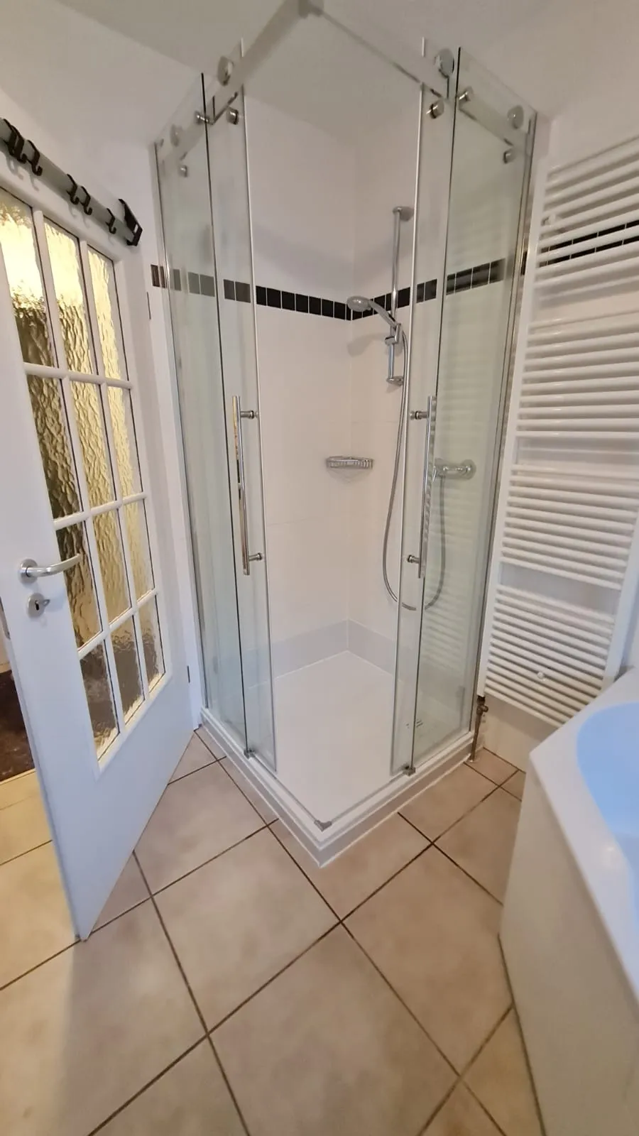 Modernes barrierefreies Bad mit neuer Eck-Glasdusche und hellen Fliesen